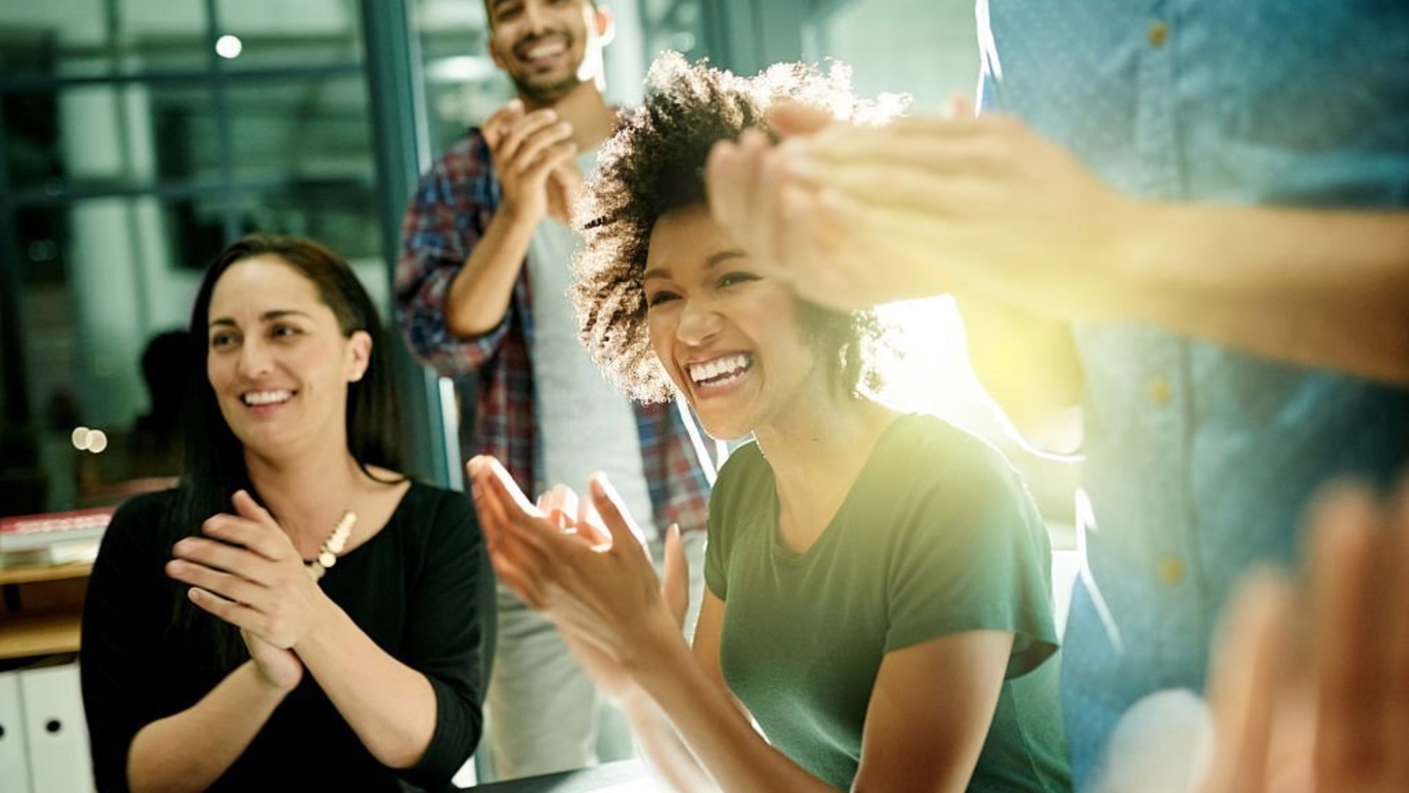 Shot of a team of creative businesspeople applauding an achievement  while working late in the boardroom