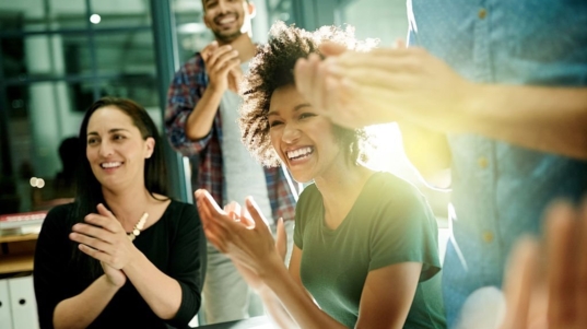 Shot of a team of creative businesspeople applauding an achievement  while working late in the boardroom